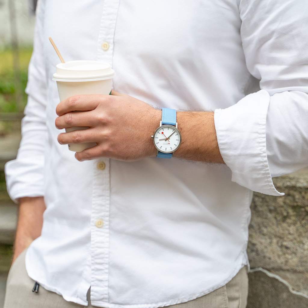 Wristwatch with a light blue strap and white face.