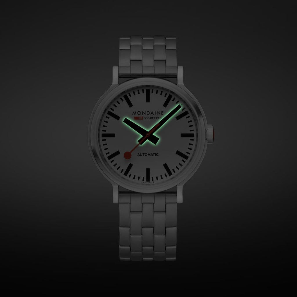 Wristwatch with luminous hands on a dark background.