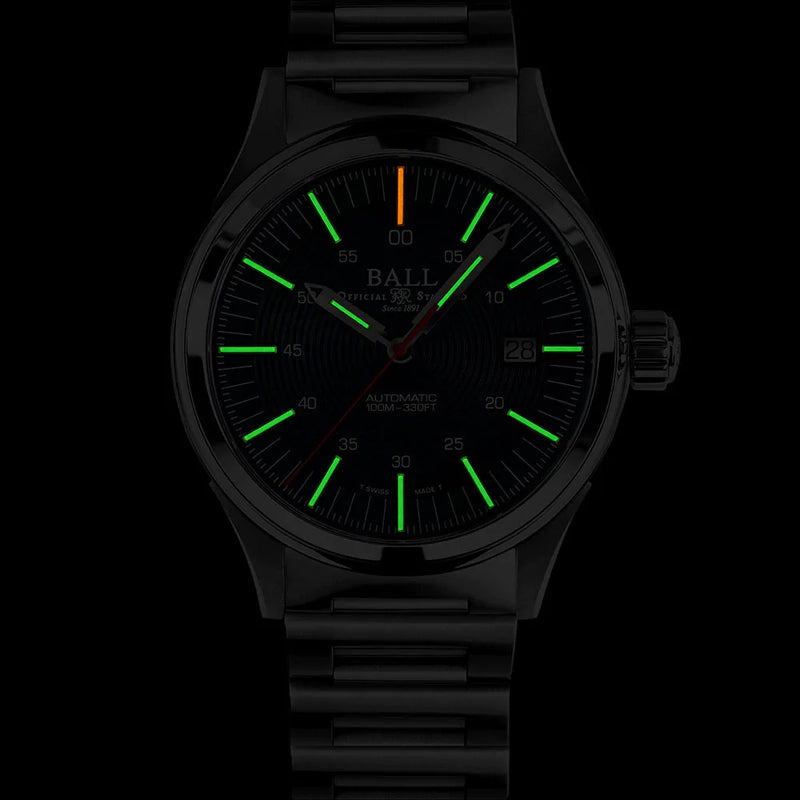 Wristwatch with glowing green hour markers and an orange second hand in a dark setting.
