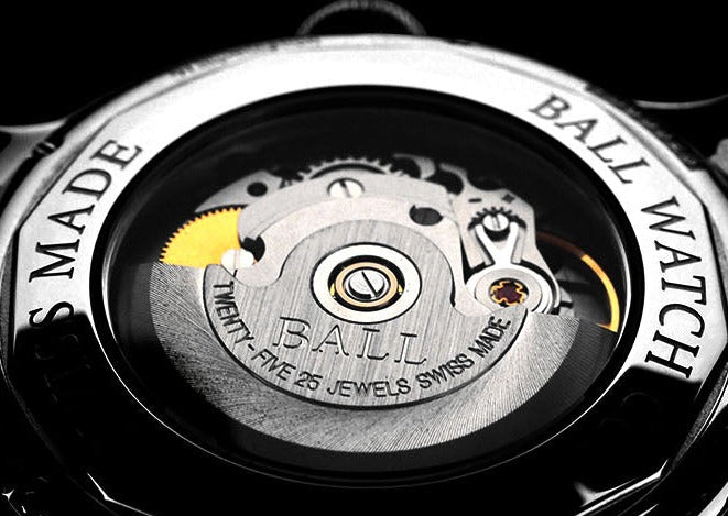 Intricate mechanical movement of a luxury watch visible through a transparent case back.