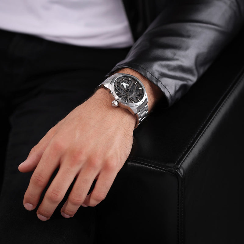 Stylish silver wristwatch with a black dial worn on a person’s wrist.