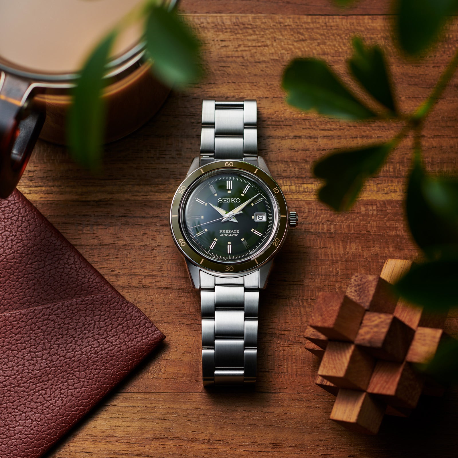 Stainless steel wristwatch with a green dial and metal bracelet.