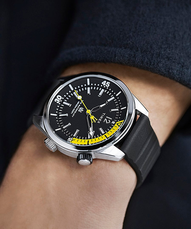 Stylish wristwatch with a black dial and yellow accents on a dark strap.