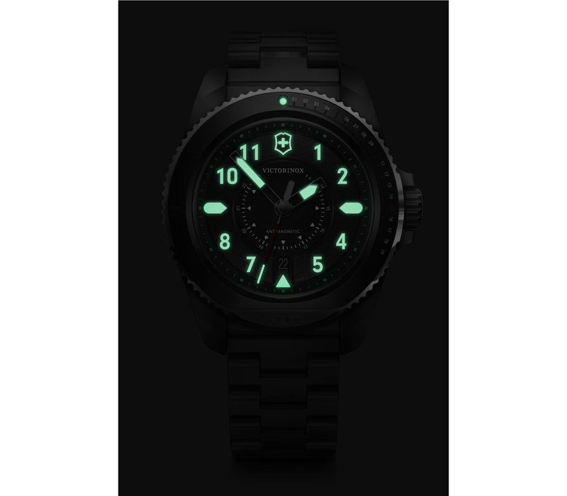 Luminous watch face with glowing green numbers and markings in darkness.