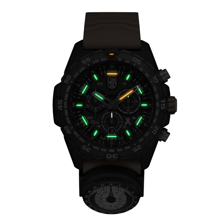 Black wristwatch with glowing green and yellow markers on the dial.