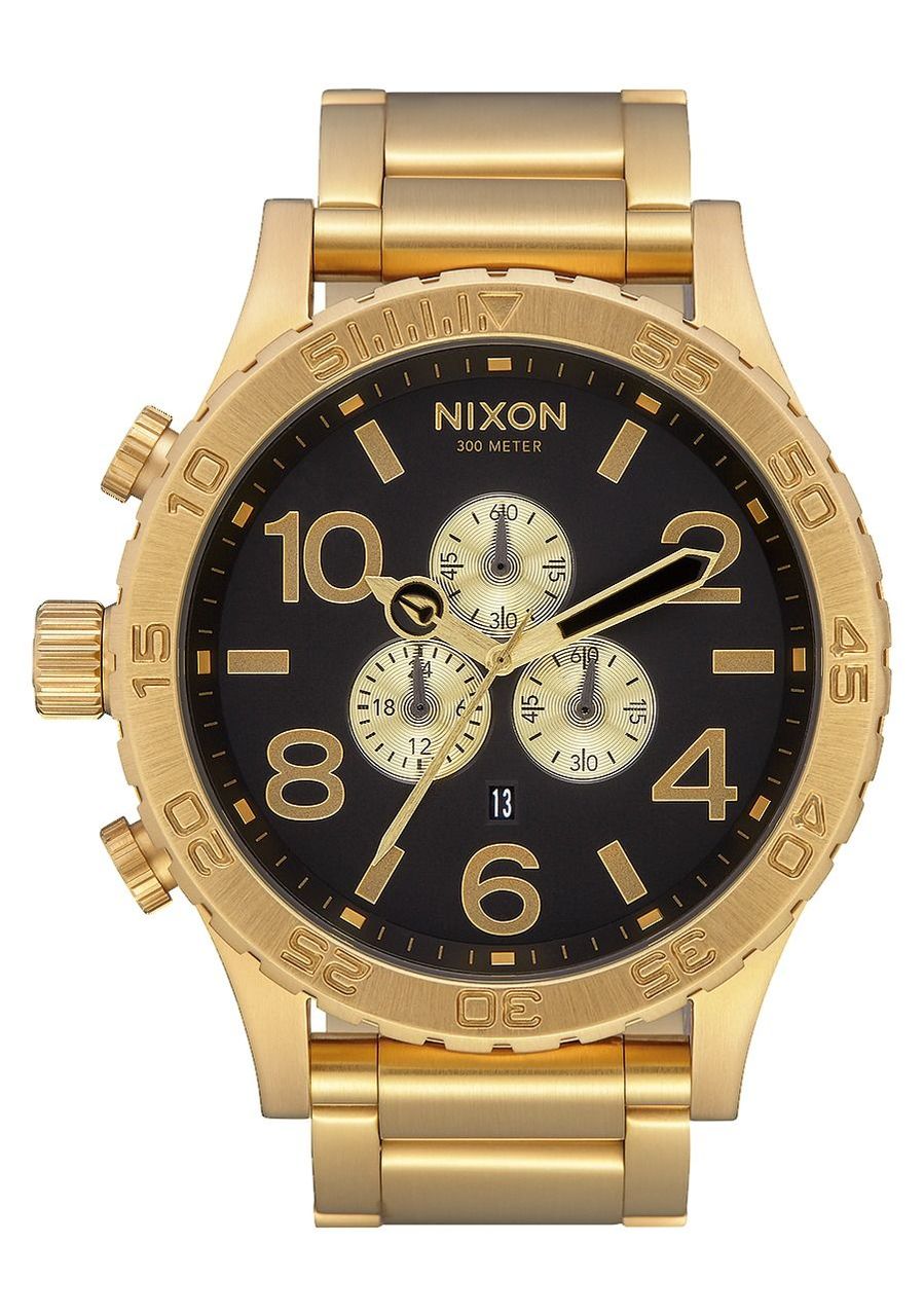 Gold-toned Nixon chronograph wristwatch with a black dial and multiple subdials.