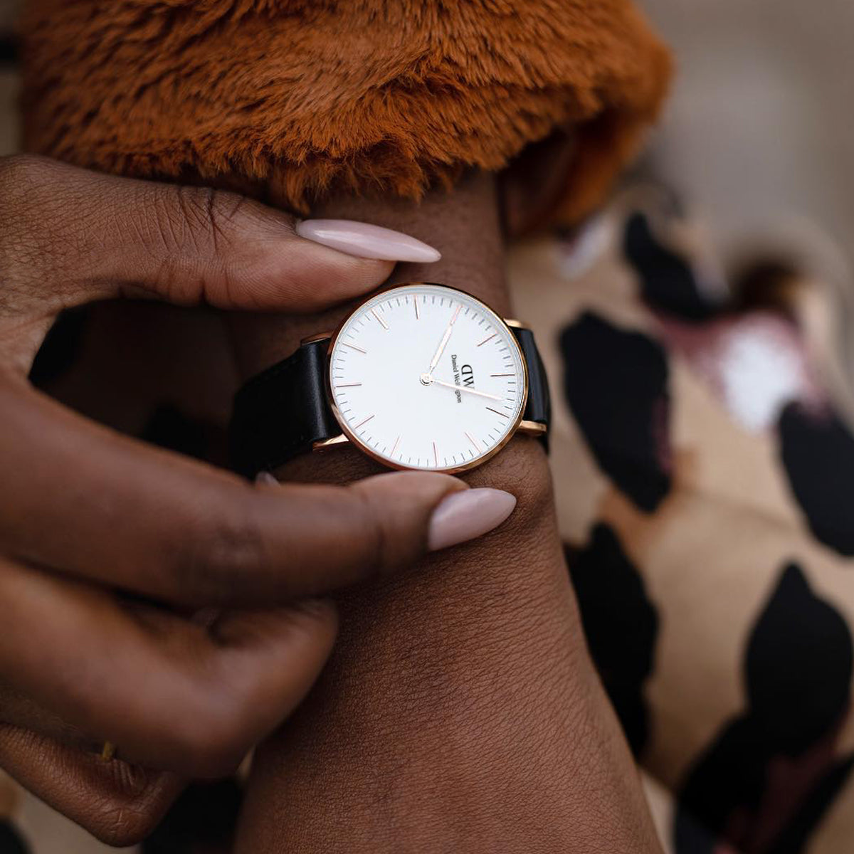 Elegant wristwatch with a white face and black leather strap.